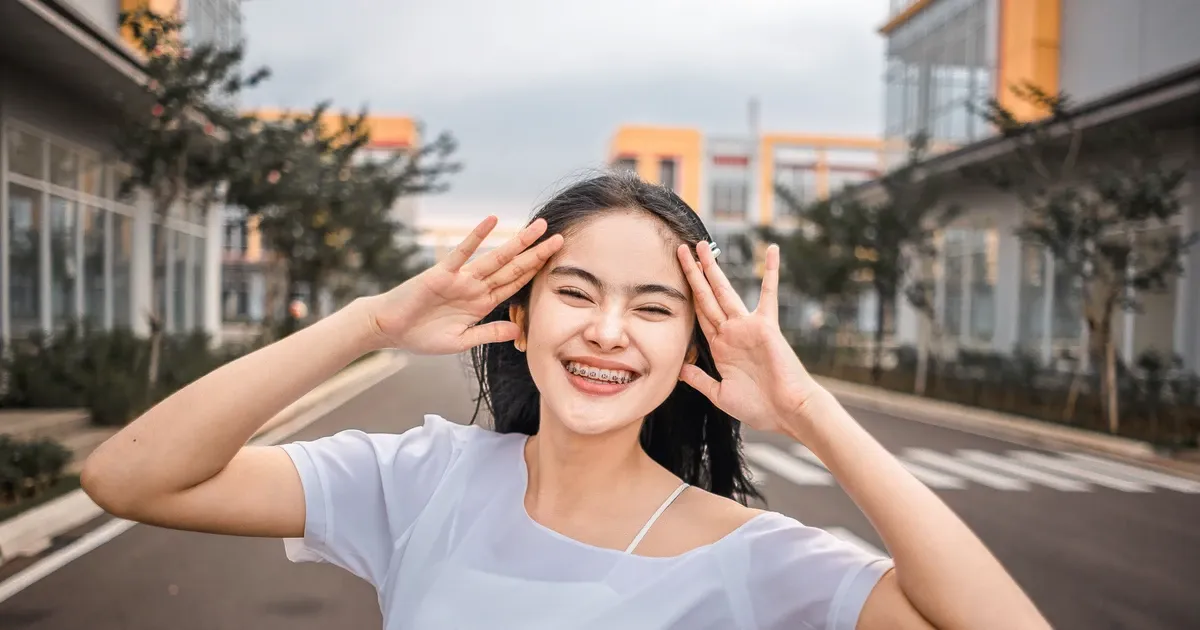 Young woman smiling confidently with braces